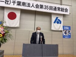 功労者表彰式開会を宣する小川副会長