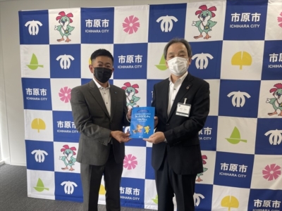 小河原青年部会長より荒井教育総務部長へ支援品贈呈 小河原青年部会長より荒井教育総務部長へ支援品贈呈